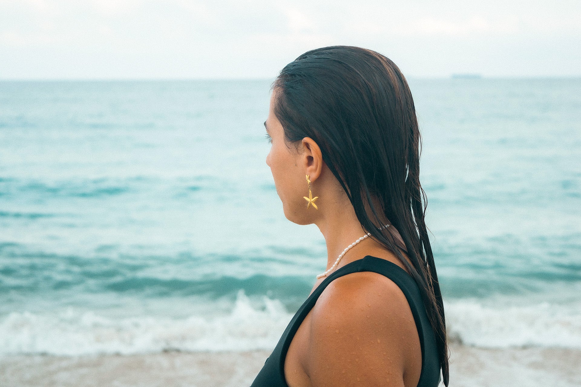 shop waterproof earrings girl look out into the ocean